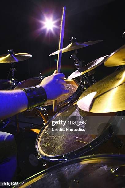 close up shot of a set of hands as they play the drums up on stage - modern rock stock pictures, royalty-free photos & images