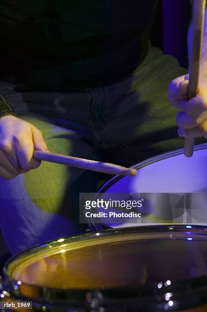 close up on a set of hands holding drum sticks as they play the drums - modern rock bildbanksfoton och bilder