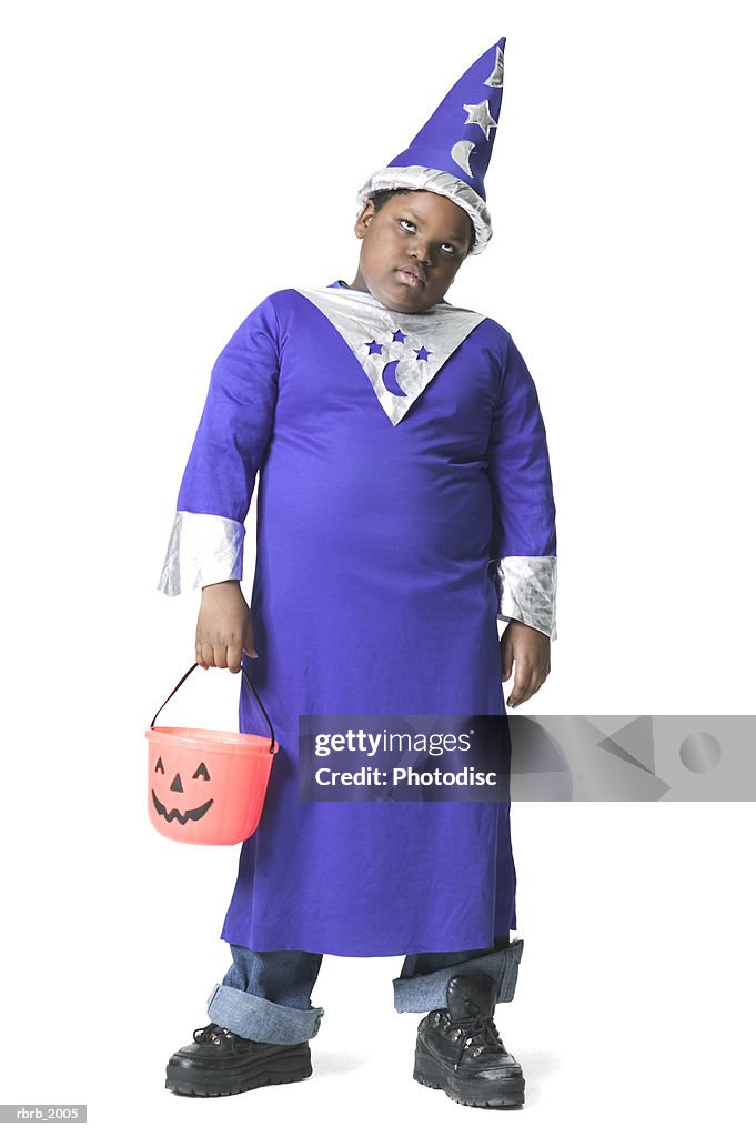 Full body shot of a slightly annoyed male child dressed as a wizard for halloween