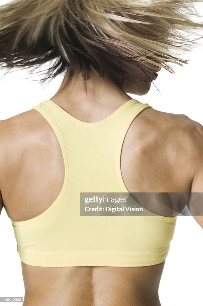Close Up Of The Muscular Back Of A Young Adult Woman In A Yellow
