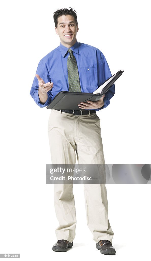 Full body shot of a young adult business man in a blue shirt and tie as he lectures form his notebook