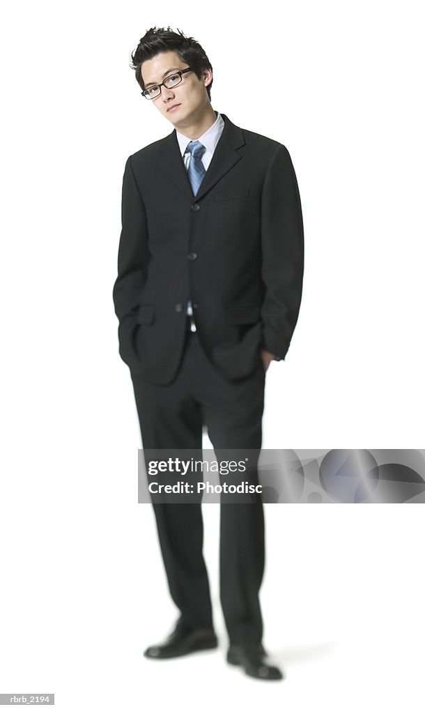 Full body shot of a young adult business man in a suit as he puts his hand on his pockets