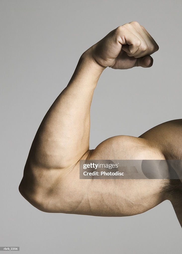 Close up of a muscular male arm as he flexes his biceps