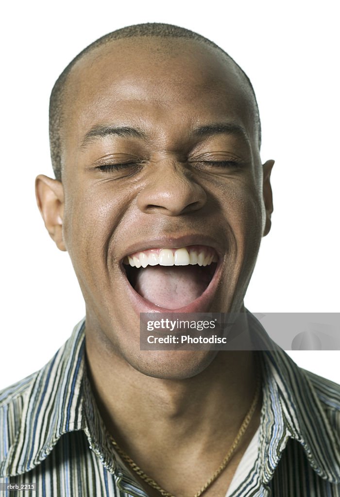Portrait of a young adult male in a striped shirt as he laughs wildly
