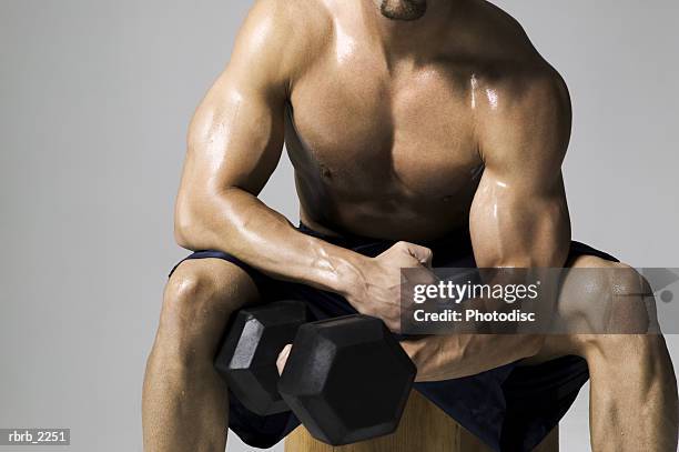 medium shot of a male bodybuilder as he lifts a weight - pectoral muscle stock pictures, royalty-free photos & images