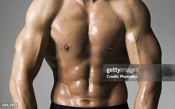 medium shot of a male bodybuilder as he flexes his stomach muscles - pectoral muscle stock pictures, royalty-free photos & images