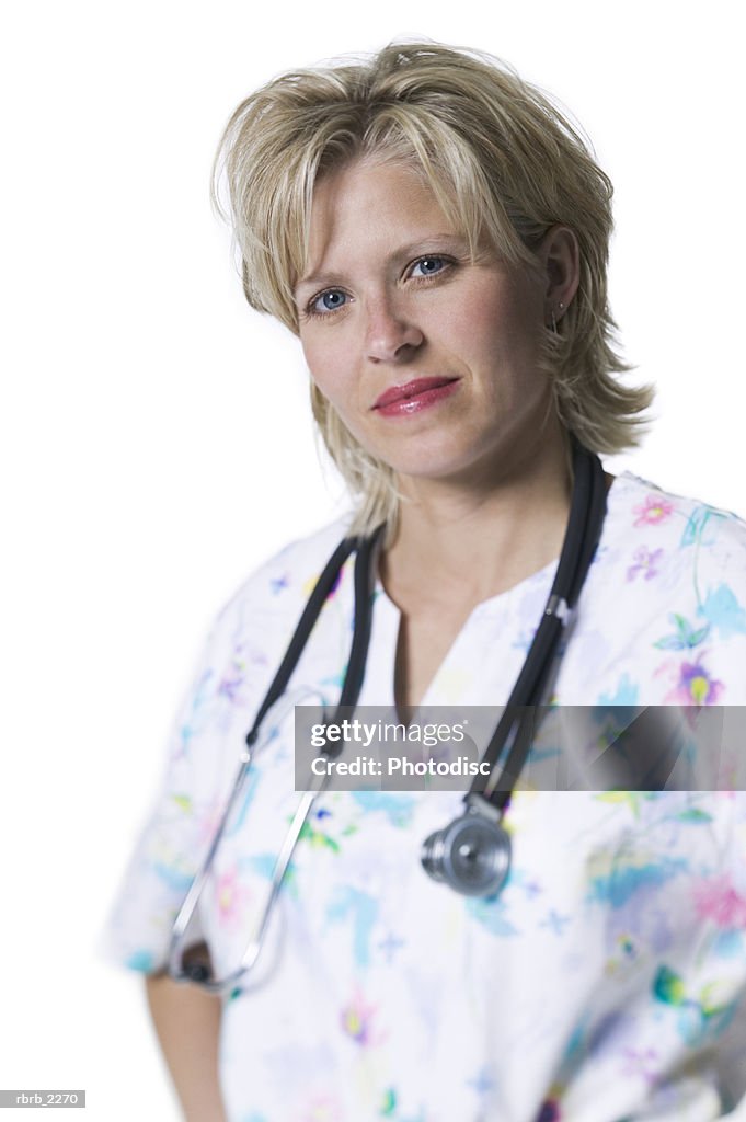 Portrait of an adult female nurse in printed scrubs as she looks at the camera