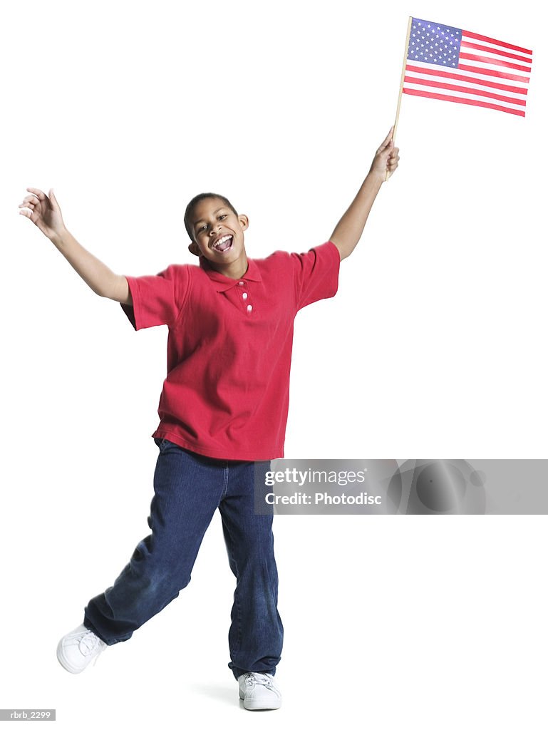 Full length shot of a teenage male in a red shirt as he jumps up waving an american flag