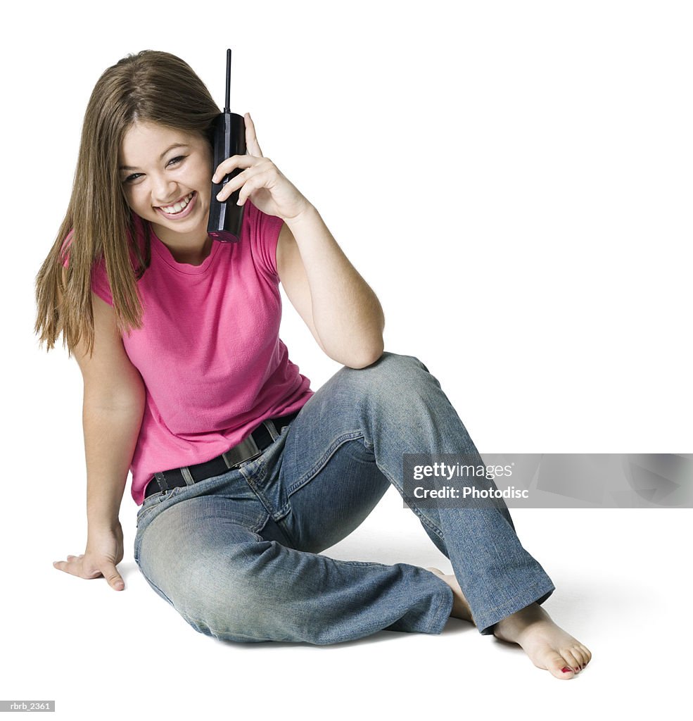 Full length youth portrait of a teenage female as she sits and chats on the phone