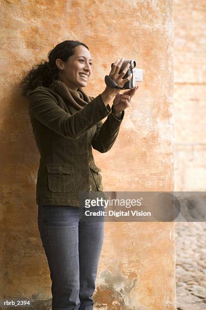 lifestyle shot of a young adult woman as she uses a digital video camera - uses stock pictures, royalty-free photos & images