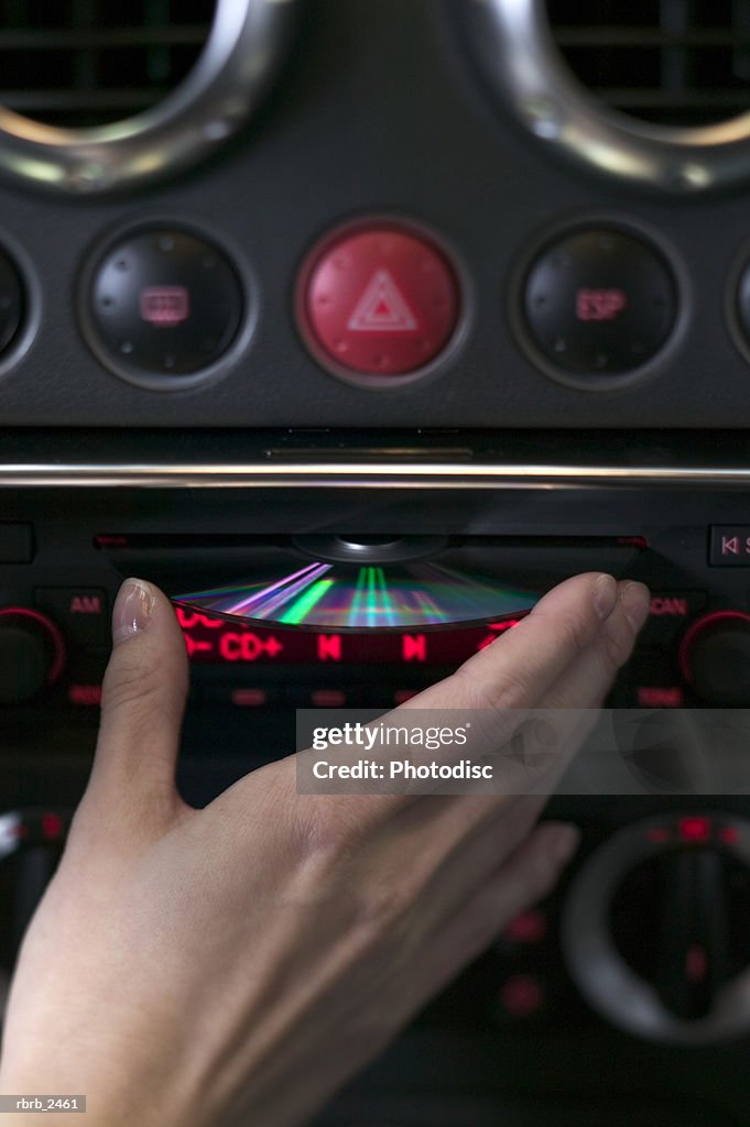Close up shot of a cd being put into a car stereo