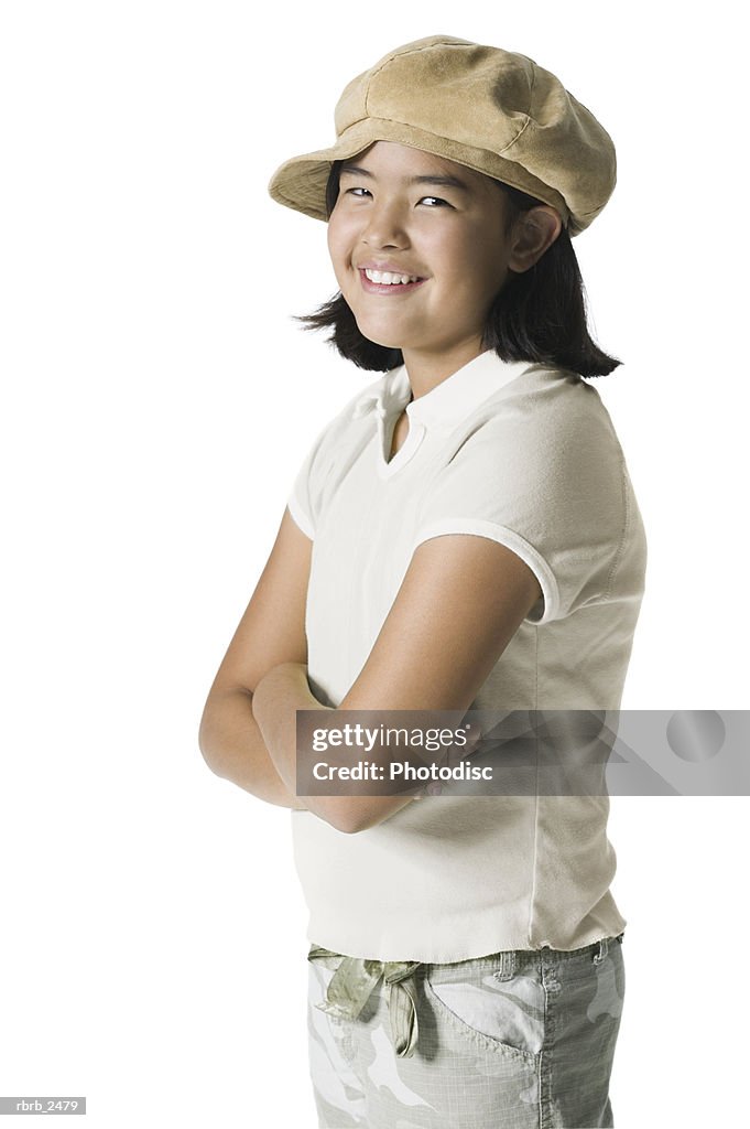 Youth portrait of a teenage female in a fun hat as she folds her arms and smile