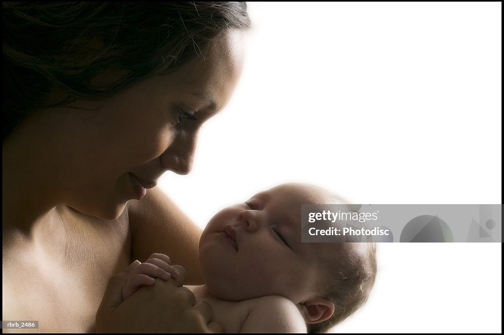 Relationship portrait of a young mother as she holds her sleeping newborn baby
