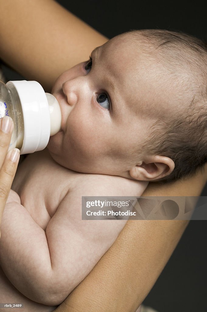 Relationship portrait of a young mother as she feeds her newborn baby