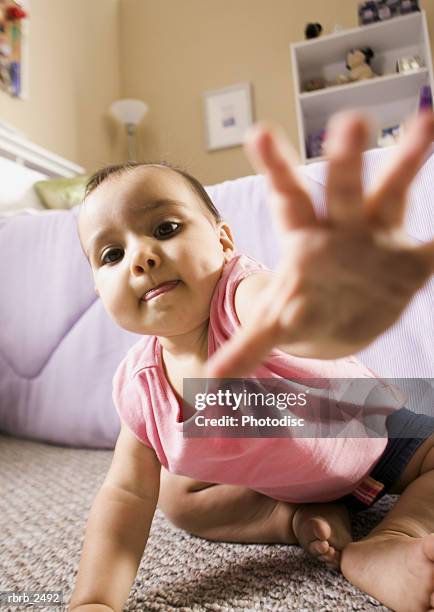 lifestyle shot of a female toddler in a pink shirt as she crawls and reaches for the camera - one baby girl only fotografías e imágenes de stock