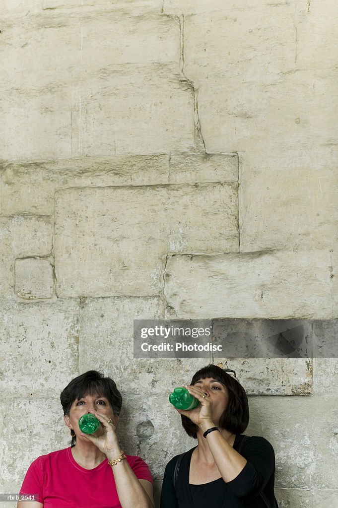 Lifestyle shot of an adult daughter and her mother as they both drink a beverage