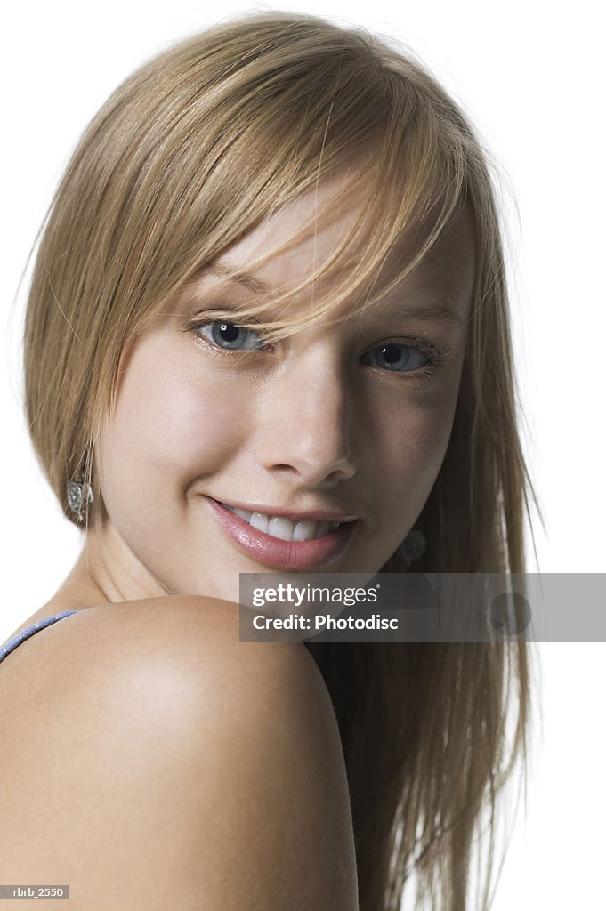 Portrait of a blonde young adult female as she turns her head and smiles