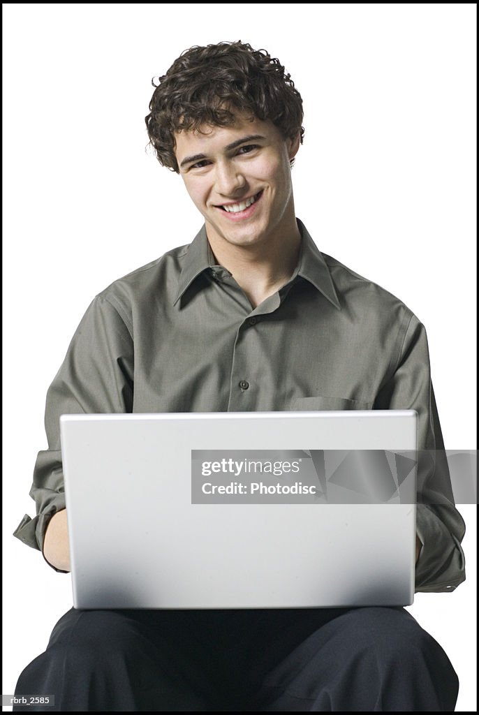 Lifestyle portrait of a young adult male in a grey shirt as he works on his laptop computer