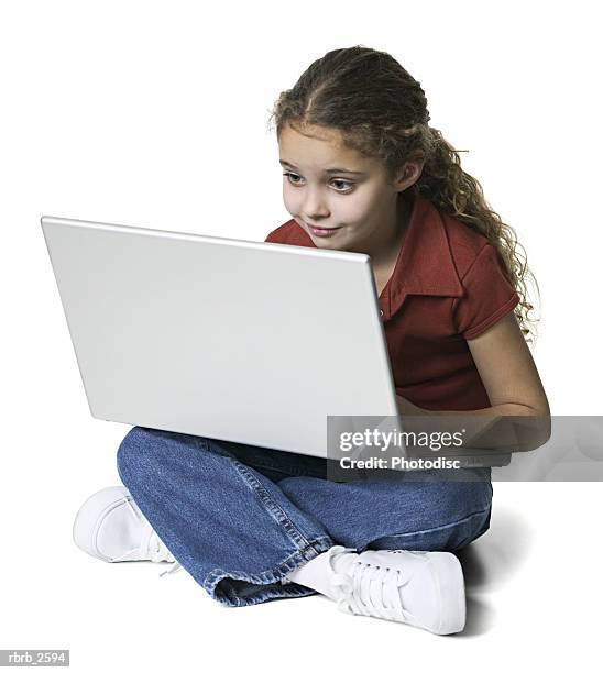 full length shot of a brunette female child as she sits and uses a laptop computer - uses stock pictures, royalty-free photos & images