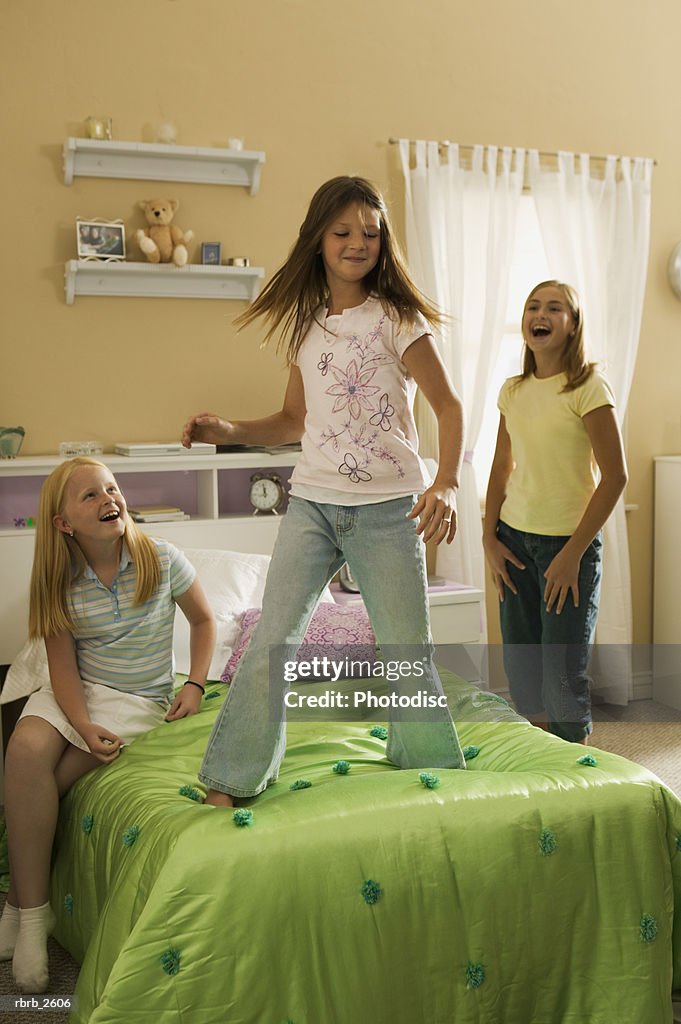 Teenage lifestyle shot of three girls as they play together in a bedroom