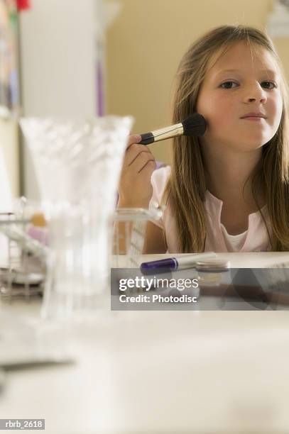 teenage lifestyle shot of a girl as she sits at a mirror and practices putting on make up - make up ストックフォトと画像