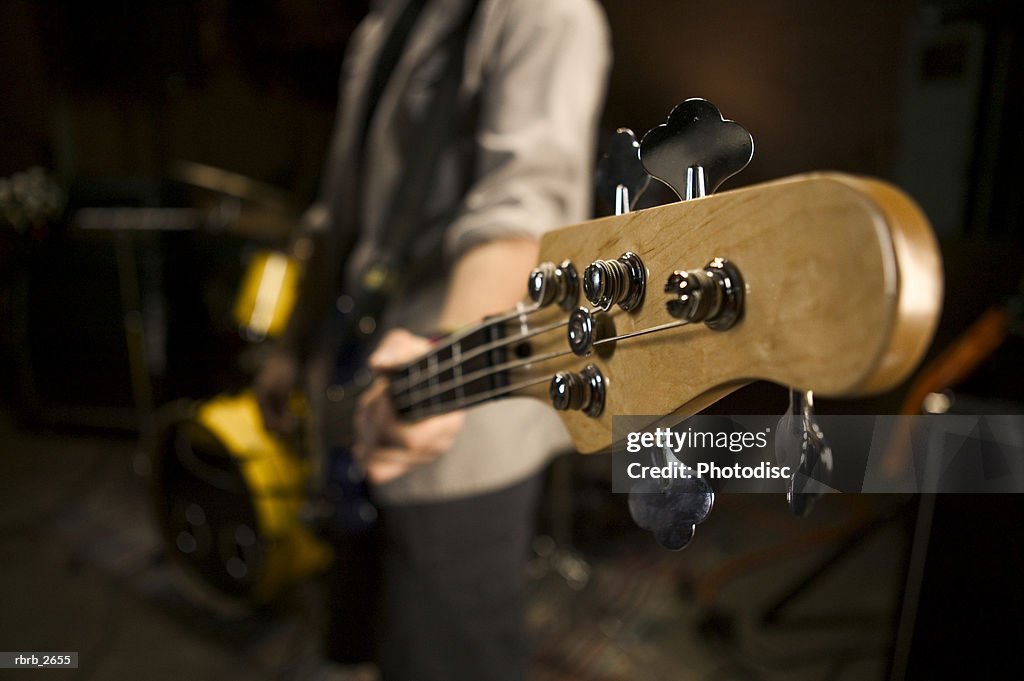 Teenage lifestyle shot of a male guitar player as he practices with his rock band