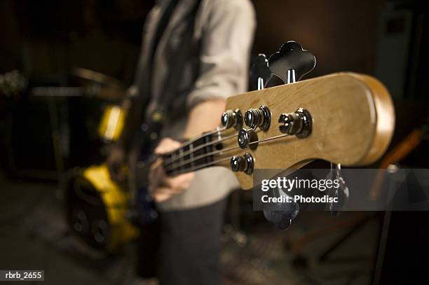 teenage lifestyle shot of a male guitar player as he practices with his rock band - modern rock stock pictures, royalty-free photos & images