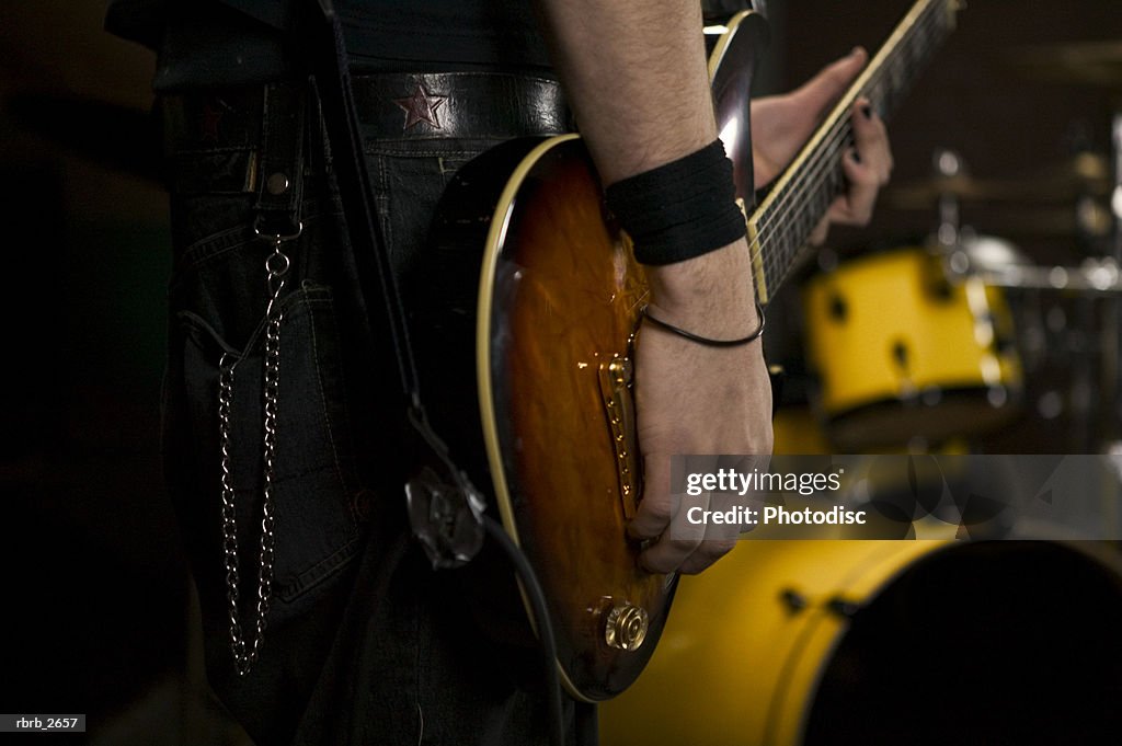 Teenage lifestyle shot of a male guitar player as he practices with his garage band