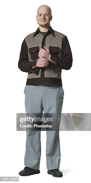 full length shot of a bald young adult male in a brown shirt as he smiles at the camera - bald stock-fotos und bilder