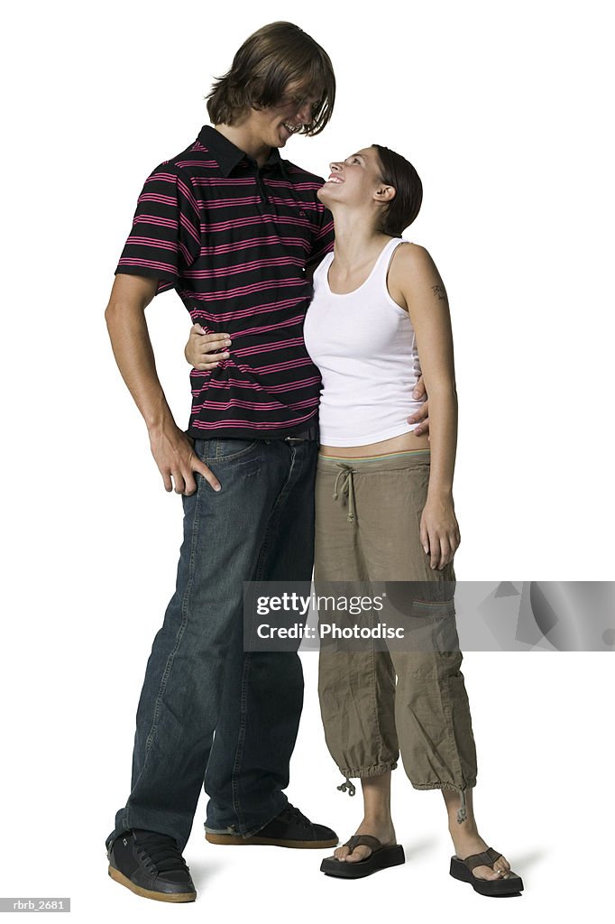 Full length shot of a young adult couple as they embrace and look into each others eyes