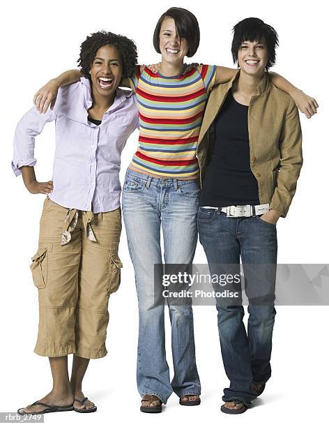 full length shot of a group of three teenage female friends as they smile at the camera - smile stock-fotos und bilder