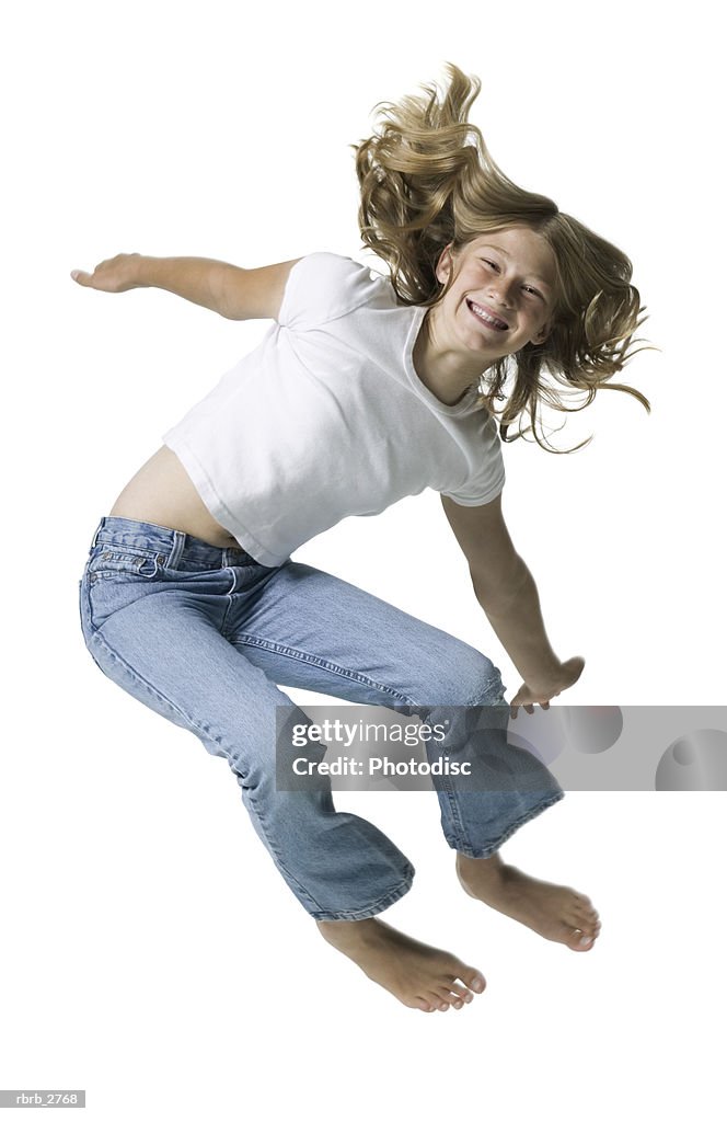 Full length shot of a teenage female in jeans and a white shirt as she jumps up