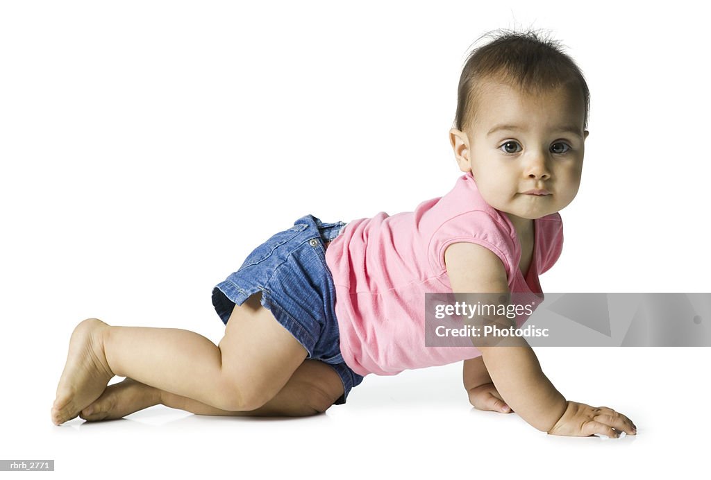 Full length shot of a female infant in a pink shirt as she crawls