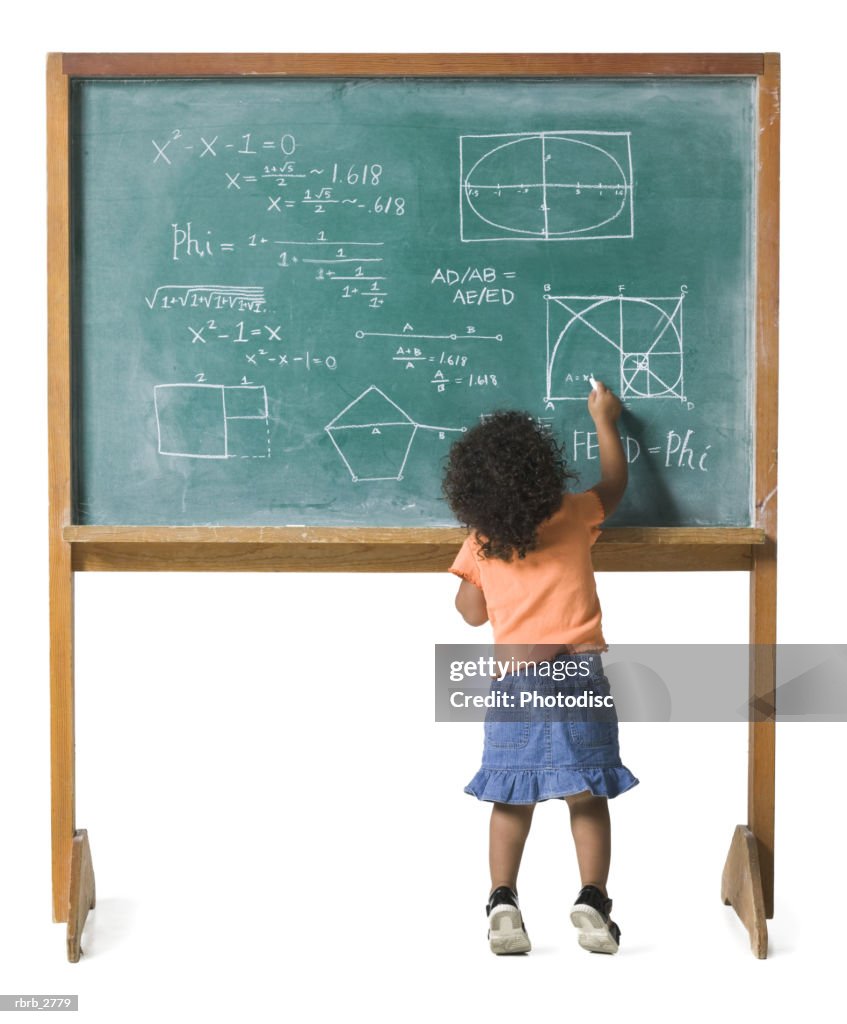 Conceptual shot of a young female child as she works out a problem on a chalkboard