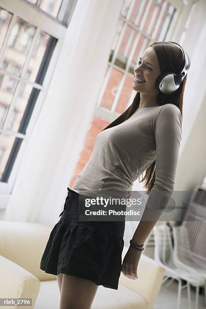 lifestyle shot of an attractive young adult female as she listens to music through headphones - electronic music 個照片及圖片檔