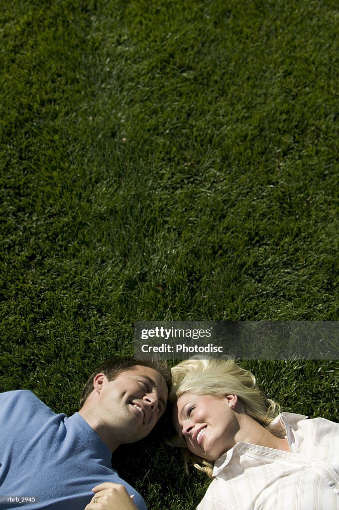 High angle view of a young couple lying on a lawn