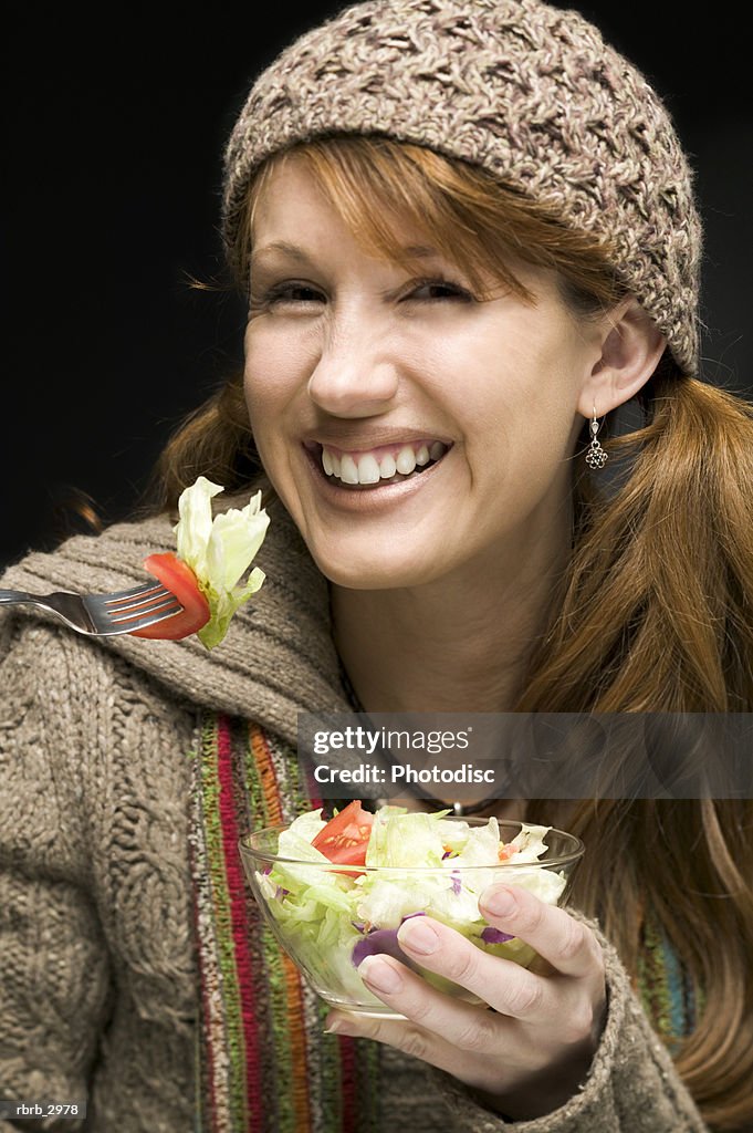 Portrait of a woman holding a bowl of salad and a fork