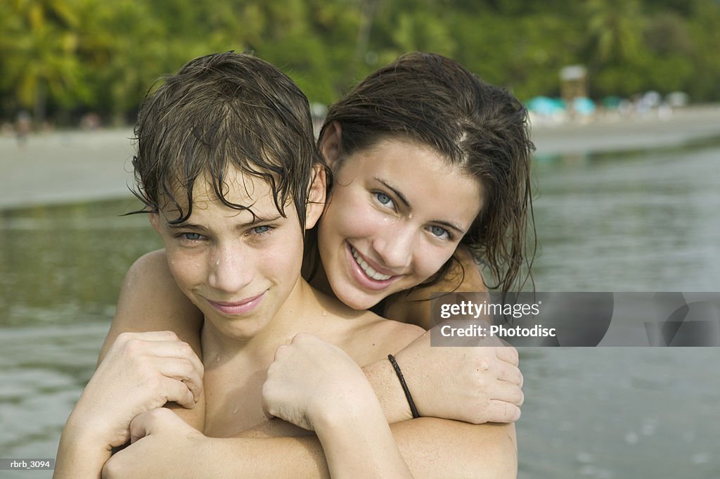 Portrait of a teenage girl holding a teenage boy