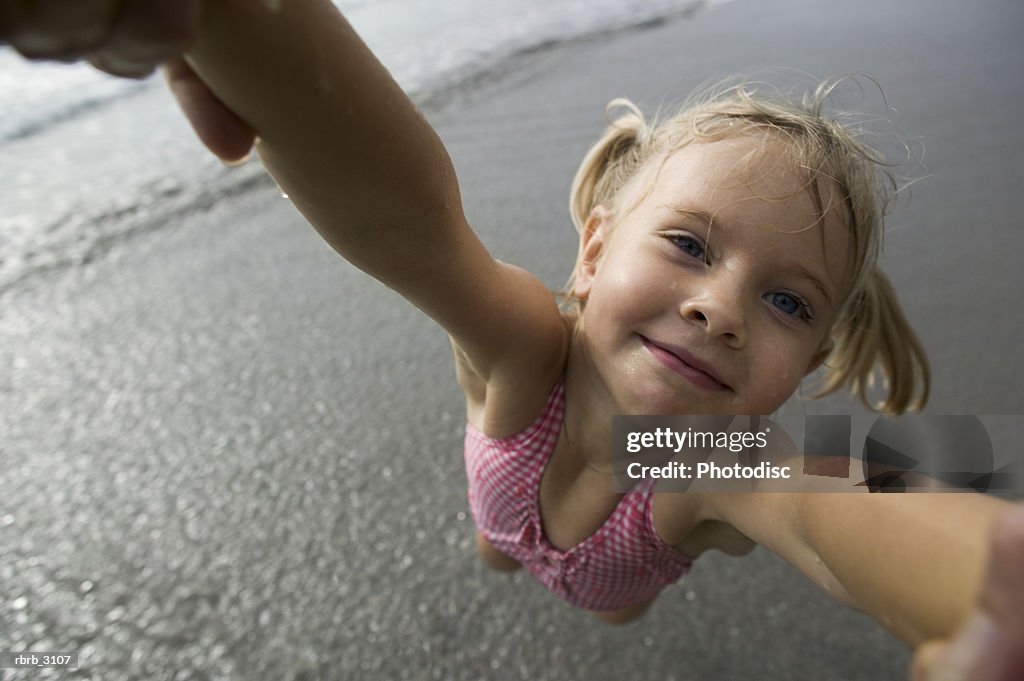 Close-up of a person spinning a girl at the beach