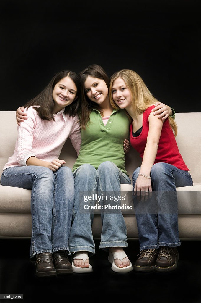 Portrait of three teenage girls sitting on a couch