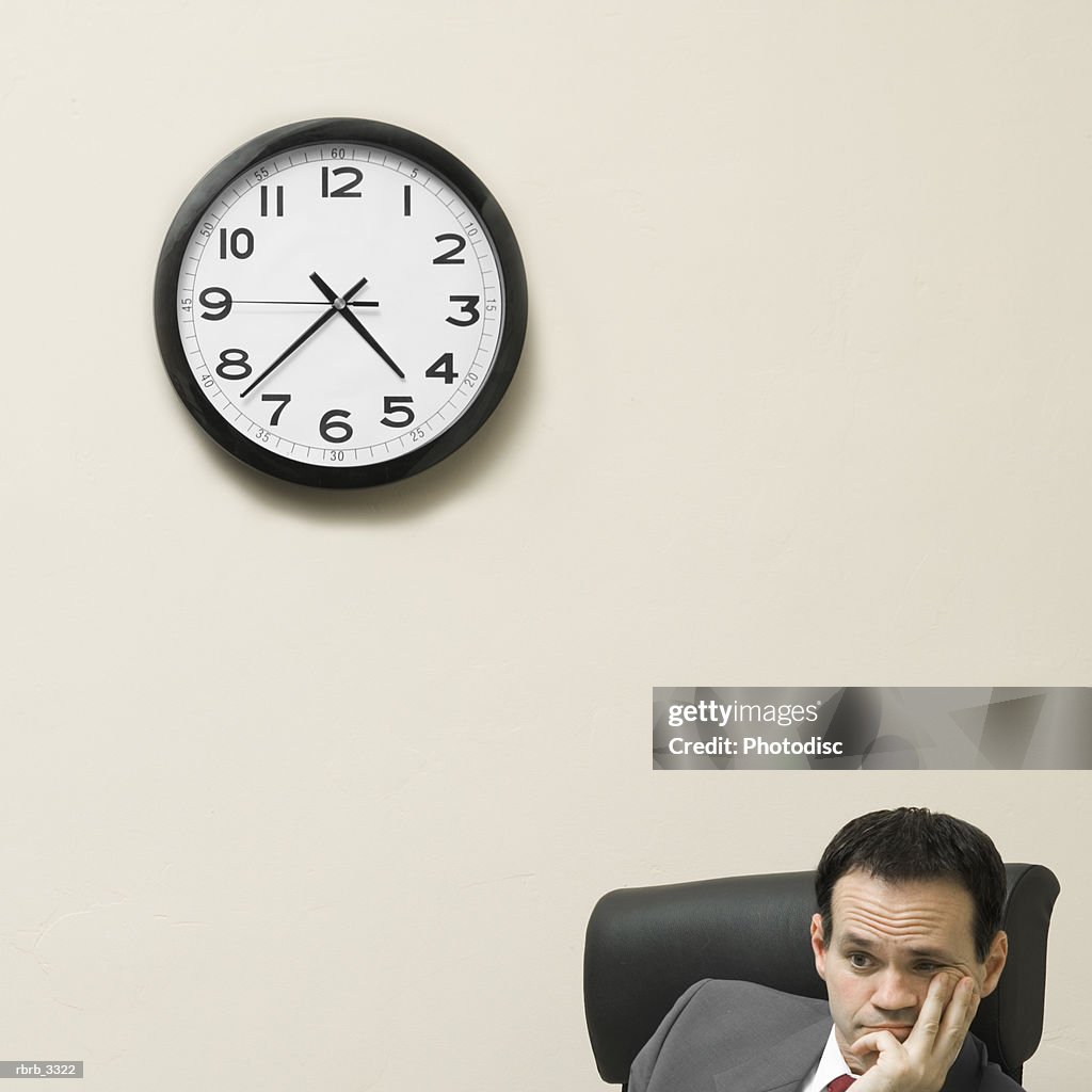 Businessman sitting behind a desk with his hands on his face