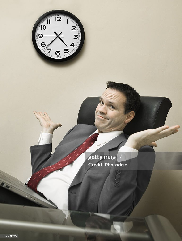 Portrait of a businessman sitting behind a desk working on a laptop