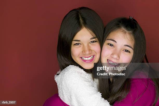 two girls (8-9) hugging each other - hair part stock-fotos und bilder