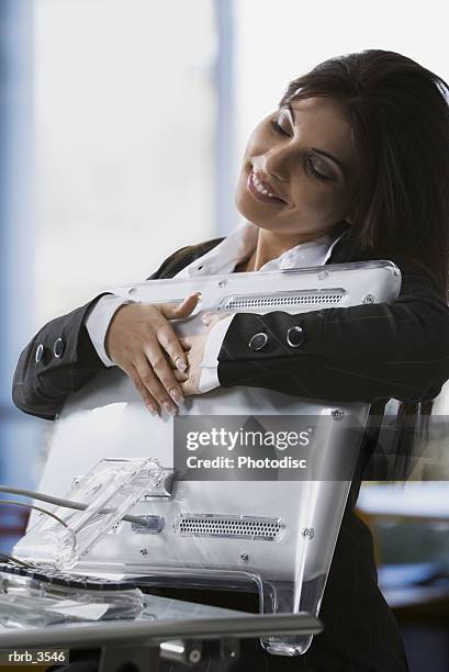 young woman holding a computer monitor with her eyes closed - technophiler mensch stock-fotos und bilder