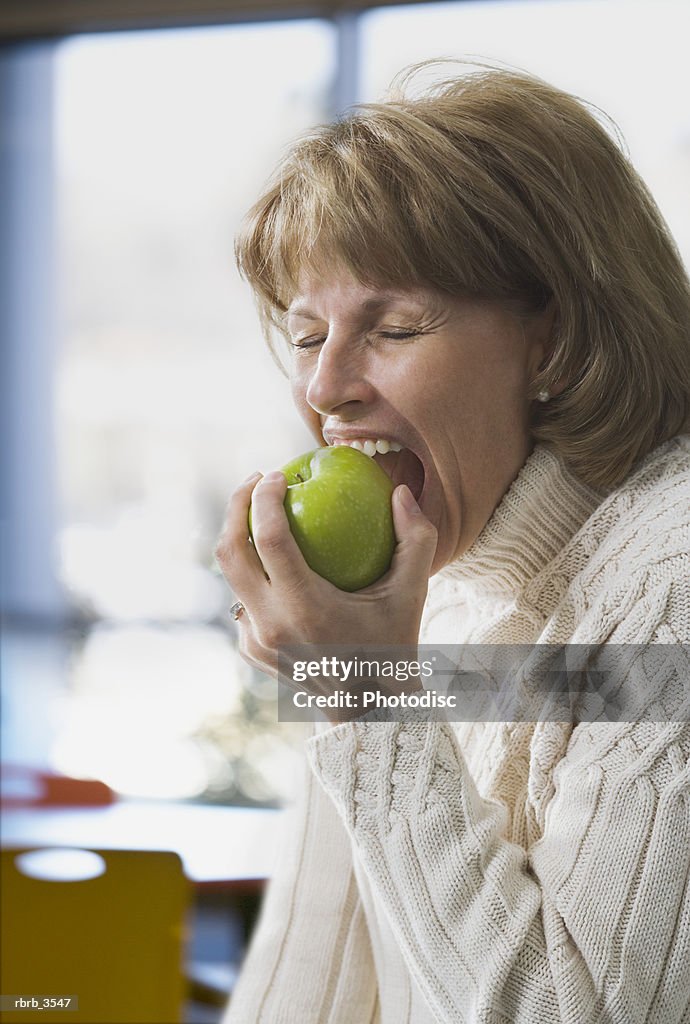 Close-up of a woman biting an apple