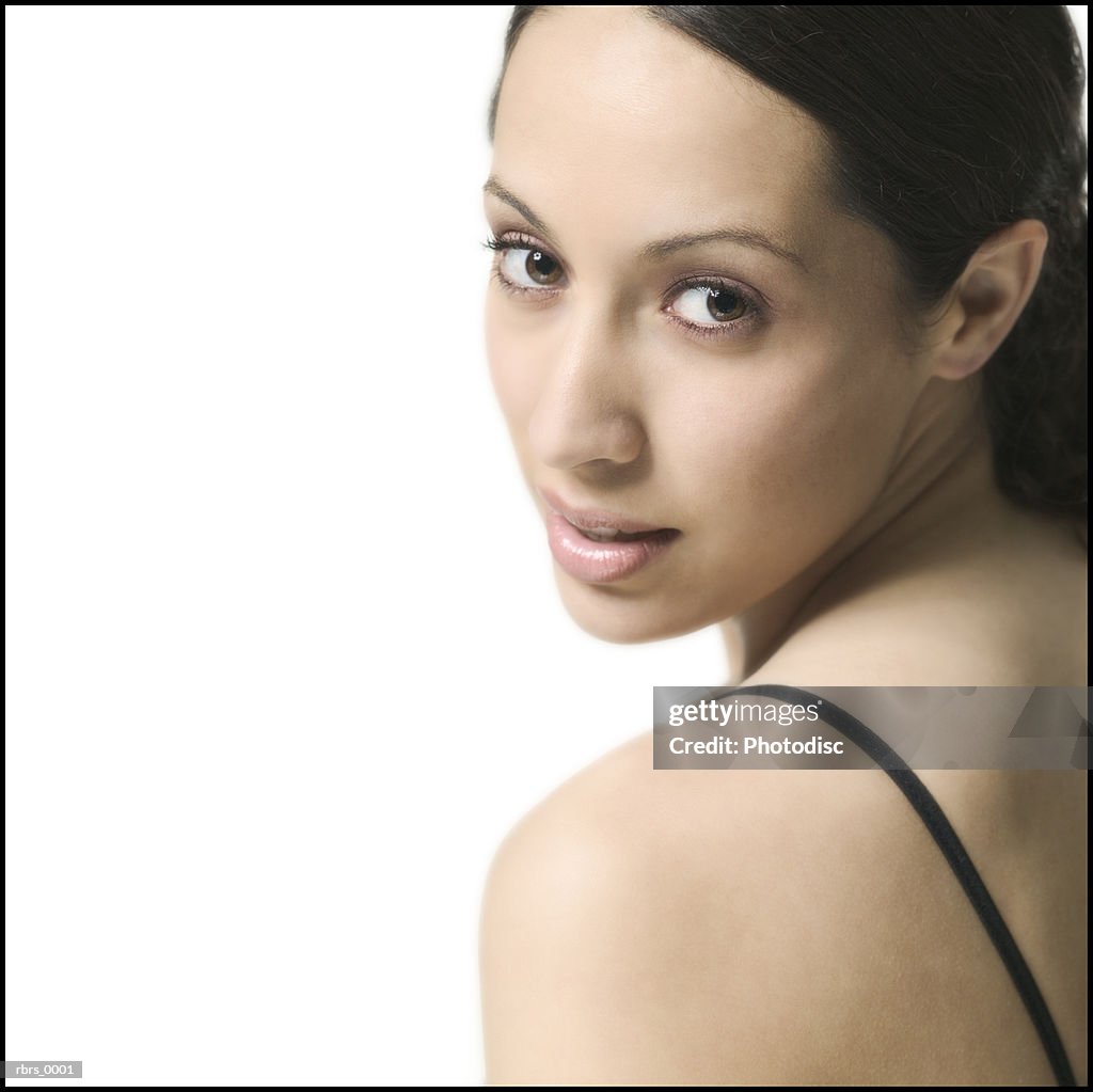 Close up shot of a brunette young adult woman as she glances over her shoulder