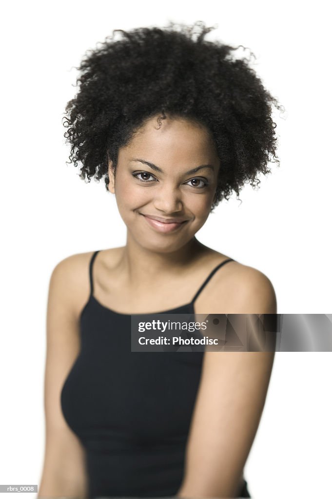 Medium shot of a young adult woman in a black tank top as she smiles