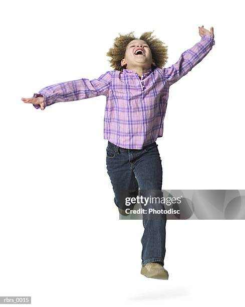 full body shot of a female child as she runs forward and throws her head back - jumping casual clothing studio shot stock-fotos und bilder