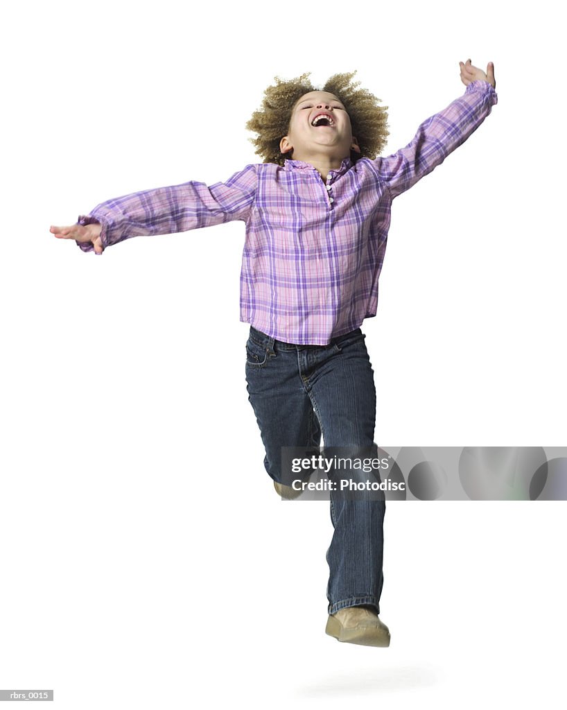 Full body shot of a female child as she runs forward and throws her head back