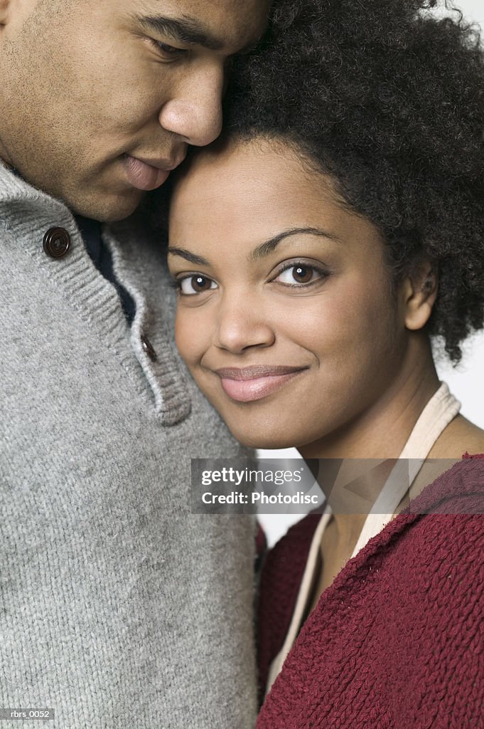 Close up shot of a young adult female as she leans against her boyfriend and smiles